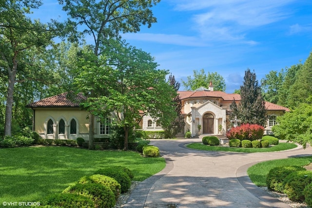 1031 Barrys Ct, Lake Forest, IL 60045 - mediterranean / spanish home featuring a tile roof, a chimney, stucco siding, and a front yard