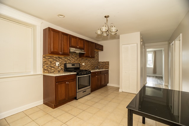 2745 S Sawyer Ave, Chicago, IL 60623 - kitchen with stainless steel gas range, under cabinet range hood, decorative backsplash, a chandelier, and decorative light fixtures