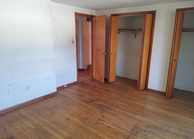 15944 Paulina St, Harvey, IL 60426 - unfurnished bedroom with hardwood / wood-style flooring and multiple closets