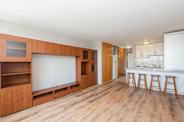 5975 N Odell Ave Unit 4F, Chicago, IL 60631 - kitchen with freestanding refrigerator, range, light wood-style flooring, a kitchen bar, and glass insert cabinets