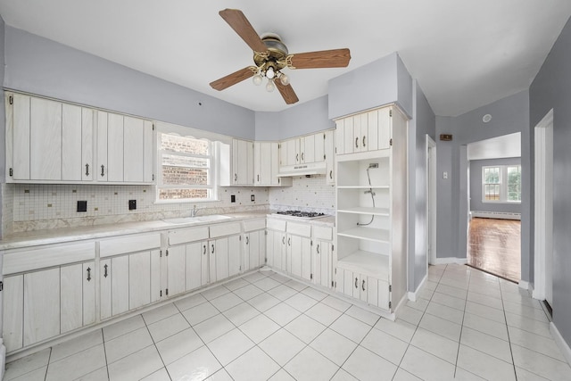 1802 S 50th Ave, Cicero, IL 60804 - kitchen featuring backsplash, light countertops, light tile patterned floors, ceiling fan, and under cabinet range hood