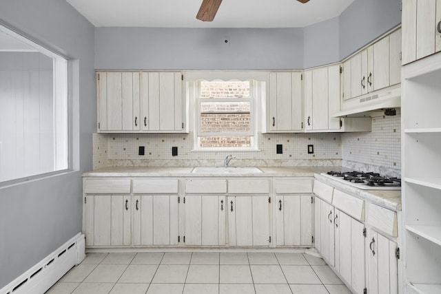 1802 S 50th Ave, Cicero, IL 60804 - kitchen with under cabinet range hood, a baseboard radiator, white gas cooktop, a ceiling fan, and tasteful backsplash