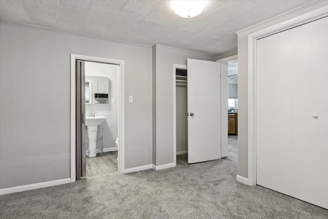 711 W Front St, Bloomington, IL 61701 - unfurnished bedroom featuring carpet flooring, multiple closets, ornamental molding, and ensuite bath