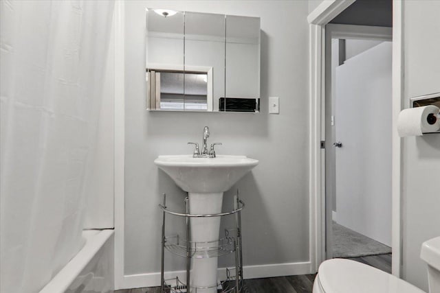 711 W Front St, Bloomington, IL 61701 - bathroom featuring wood finished floors and shower / bath combination with curtain