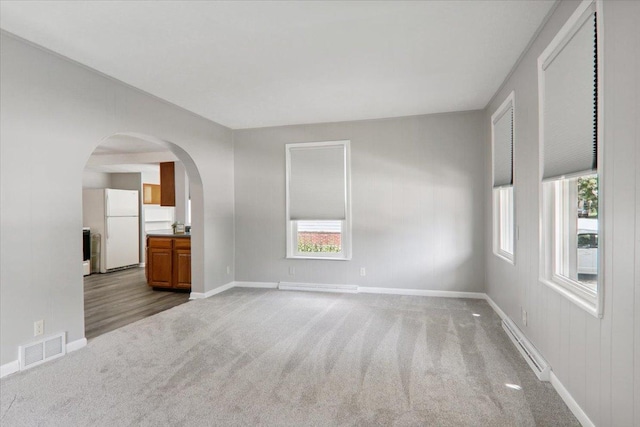 711 W Front St, Bloomington, IL 61701 - empty room with a baseboard radiator, carpet floors, and arched walkways