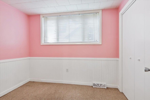 711 W Front St, Bloomington, IL 61701 - carpeted spare room featuring a wainscoted wall
