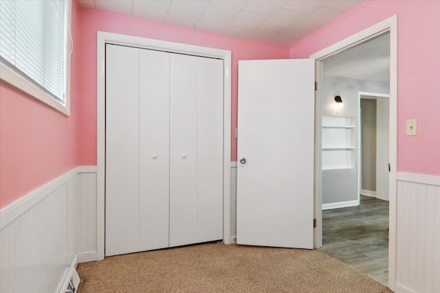 711 W Front St, Bloomington, IL 61701 - unfurnished bedroom featuring wainscoting, a closet, and wood finished floors