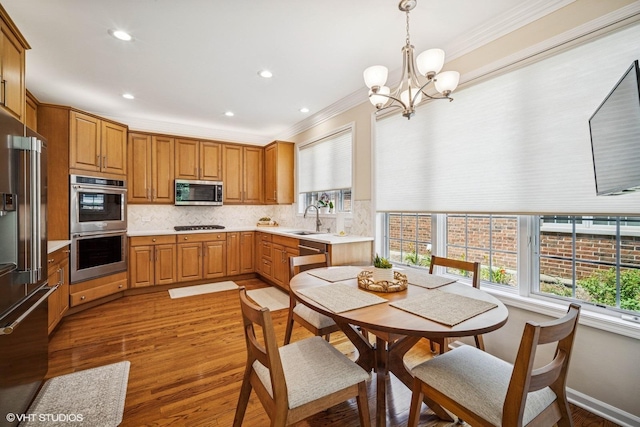 823 Balmoral Ln, Northbrook, IL 60062 - kitchen with stainless steel appliances, crown molding, decorative backsplash, light countertops, and light wood finished floors