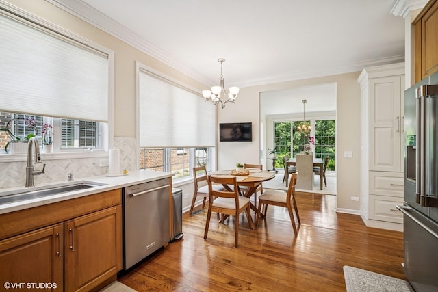 823 Balmoral Ln, Northbrook, IL 60062 - kitchen featuring stainless steel appliances, a chandelier, brown cabinetry, wood finished floors, and ornamental molding