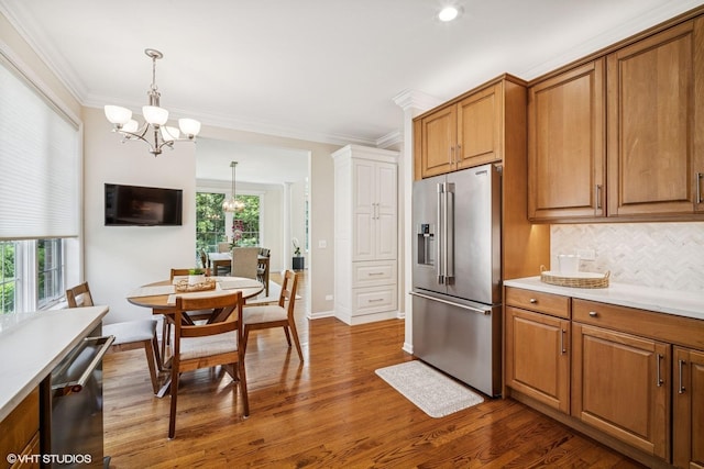 823 Balmoral Ln, Northbrook, IL 60062 - kitchen with appliances with stainless steel finishes, brown cabinetry, dark wood-style flooring, crown molding, and a chandelier