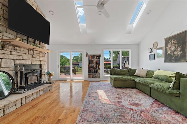 10067 W Logan Ct, Zion, IL 60099 - living room featuring a skylight, ceiling fan, high vaulted ceiling, wood finished floors, and a wood stove