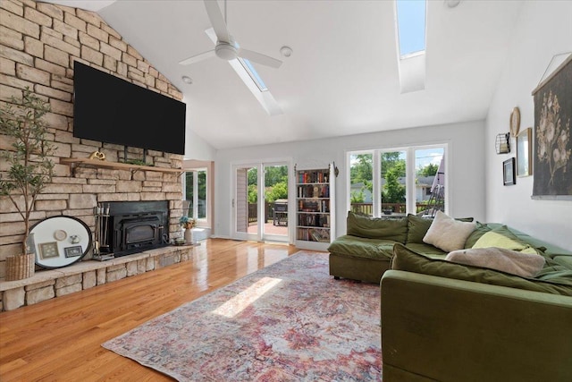 10067 W Logan Ct, Zion, IL 60099 - living area featuring a skylight, wood finished floors, high vaulted ceiling, a ceiling fan, and a wood stove