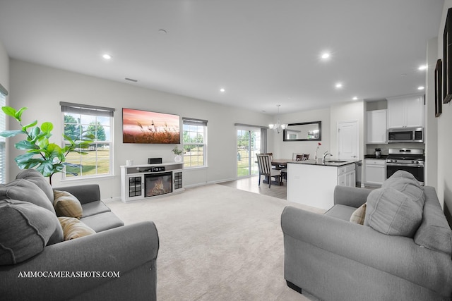 3376 Helene Rieder Dr, Montgomery, IL 60538 - living room with recessed lighting, a glass covered fireplace, a chandelier, and light colored carpet