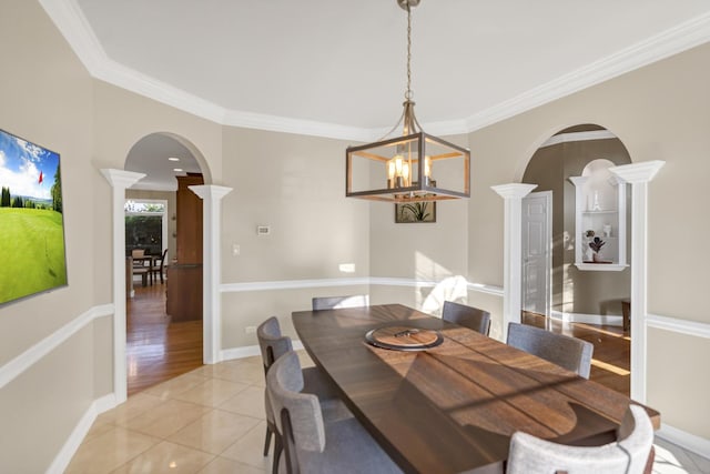 1123 Chadwick Ct, Aurora, IL 60502 - dining area featuring arched walkways, ornate columns, crown molding, light tile patterned flooring, and a chandelier