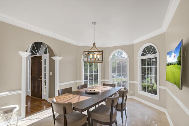 1123 Chadwick Ct, Aurora, IL 60502 - dining room featuring a chandelier, ornamental molding, arched walkways, and light tile patterned floors