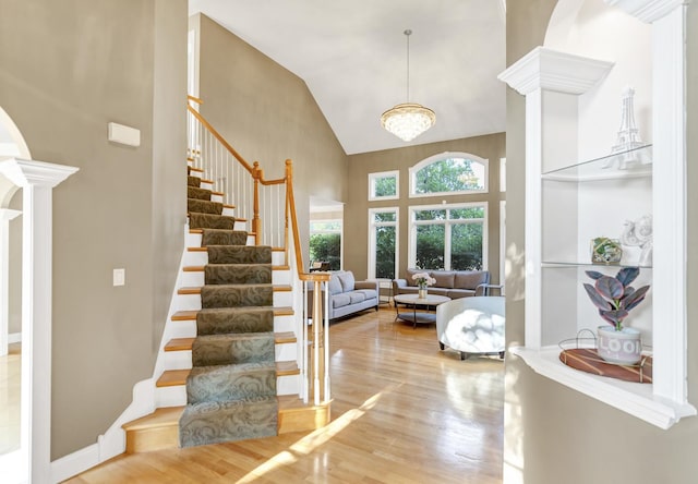 1123 Chadwick Ct, Aurora, IL 60502 - foyer featuring ornate columns, high vaulted ceiling, wood finished floors, and stairs