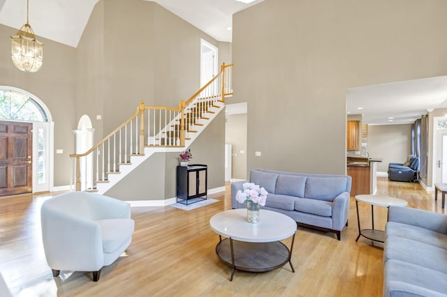 1123 Chadwick Ct, Aurora, IL 60502 - living area with a towering ceiling, stairs, light wood finished floors, and a chandelier
