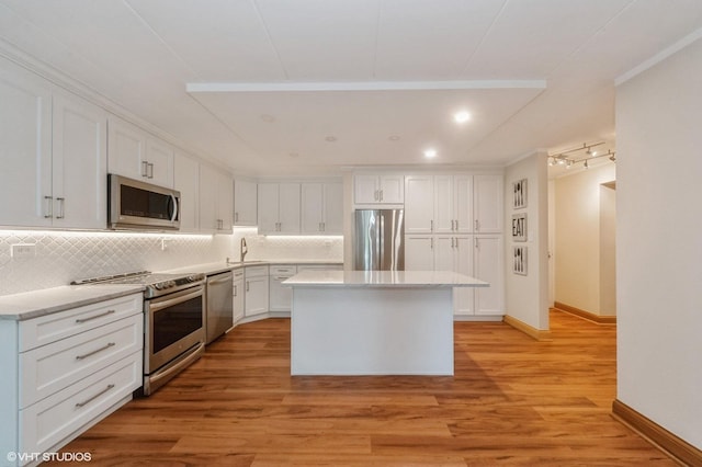 18 E Old Willow Rd Unit 106N, Prospect Heights, IL 60070 - kitchen with appliances with stainless steel finishes, white cabinetry, tasteful backsplash, a center island, and light countertops