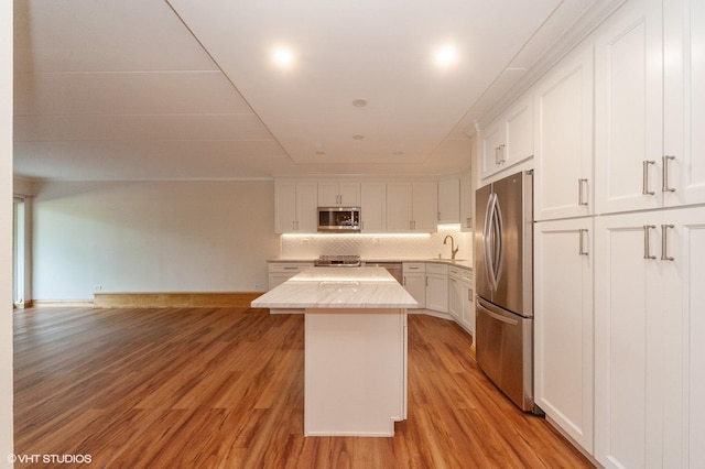 18 E Old Willow Rd Unit 106N, Prospect Heights, IL 60070 - kitchen with appliances with stainless steel finishes, a center island, white cabinetry, light countertops, and tasteful backsplash