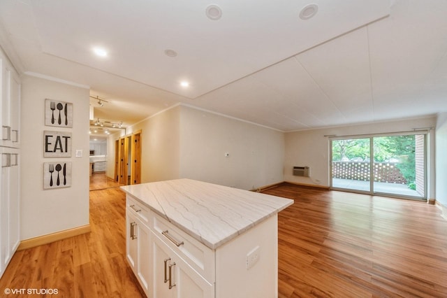 18 E Old Willow Rd Unit 106N, Prospect Heights, IL 60070 - kitchen featuring a center island, light wood-style flooring, a wall mounted air conditioner, white cabinetry, and open floor plan