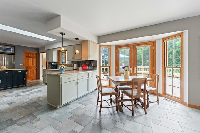 3063 Wedgewood Dr, Dekalb, IL 60115 - kitchen with freestanding refrigerator, a peninsula, decorative light fixtures, backsplash, and french doors