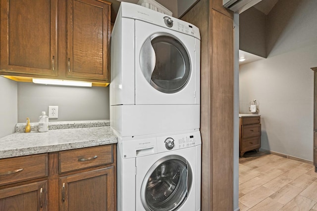 3063 Wedgewood Dr, Dekalb, IL 60115 - washroom with stacked washing machine and dryer, cabinet space, and light wood finished floors