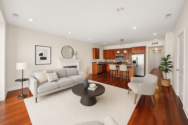 7443 W Irving Park Rd Unit 4E, Chicago, IL 60634 - living area featuring dark wood-style flooring, recessed lighting, and a fireplace