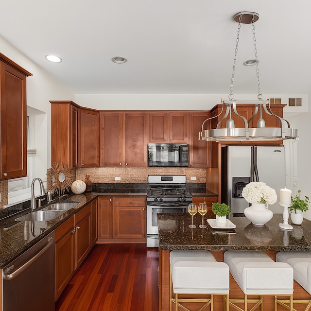 7443 W Irving Park Rd Unit 4E, Chicago, IL 60634 - kitchen featuring stainless steel appliances, dark wood-style flooring, tasteful backsplash, a kitchen breakfast bar, and recessed lighting