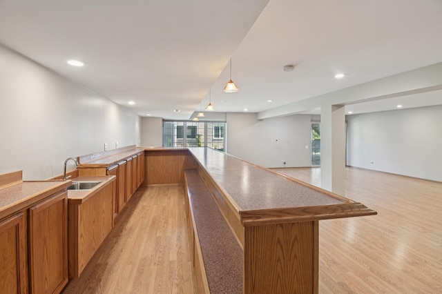 11636 Waterway Ct, Orland Park, IL 60467 - kitchen with light wood finished floors, open floor plan, brown cabinets, recessed lighting, and hanging light fixtures