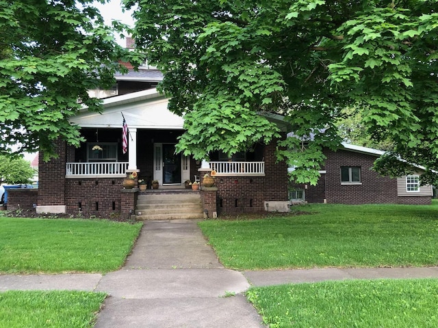 503 N Center St, Colfax, IL 61728 - view of front facade with a front lawn, covered porch, and brick siding