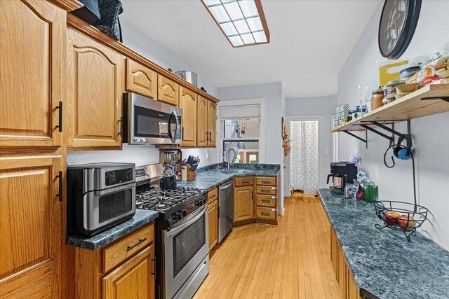 126 N Austin Blvd Unit 2N, Oak Park, IL 60302 - kitchen with appliances with stainless steel finishes, light wood-type flooring, brown cabinetry, and dark stone counters