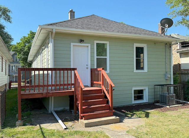 30 E 102nd St, Chicago, IL 60628 - back of property featuring a chimney, a shingled roof, and a deck