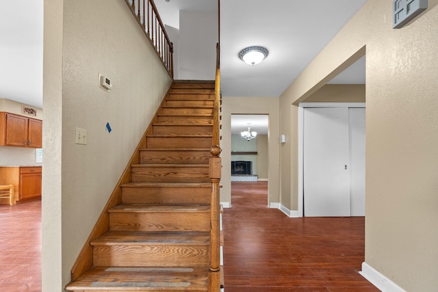 739 Crest Ave, Schaumburg, IL 60193 - stairs with wood finished floors, a textured wall, and a brick fireplace