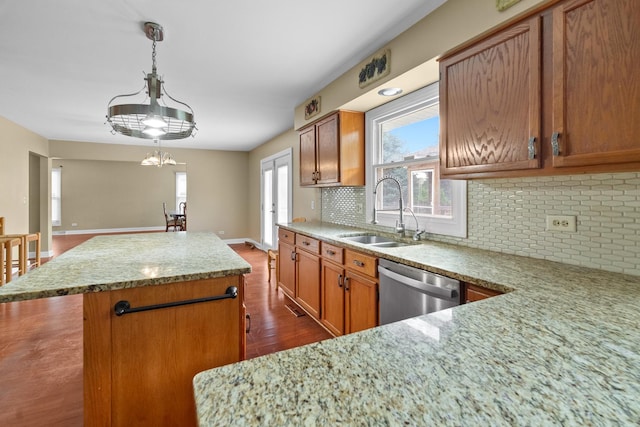 739 Crest Ave, Schaumburg, IL 60193 - kitchen featuring stainless steel dishwasher, a kitchen island, tasteful backsplash, light stone countertops, and brown cabinets