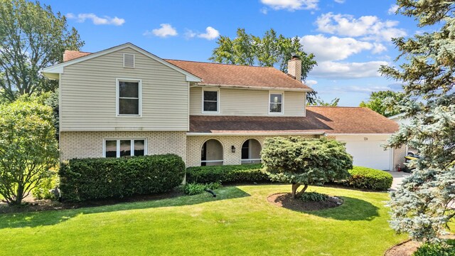 739 Crest Ave, Schaumburg, IL 60193 - traditional home with an attached garage, brick siding, a chimney, and a front yard