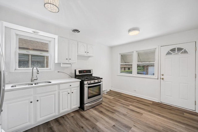 7826 S Kenneth Ave, Chicago, IL 60652 - kitchen with stainless steel range with gas stovetop, light countertops, dark wood-style flooring, and white cabinets