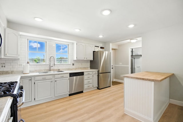34W928 N James Dr, Saint Charles, IL 60174 - kitchen featuring appliances with stainless steel finishes, backsplash, light wood-type flooring, white cabinetry, and recessed lighting