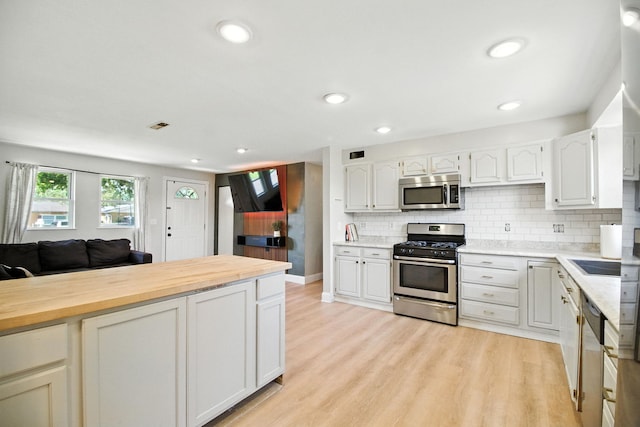 34W928 N James Dr, Saint Charles, IL 60174 - kitchen with appliances with stainless steel finishes, white cabinetry, light wood finished floors, tasteful backsplash, and recessed lighting