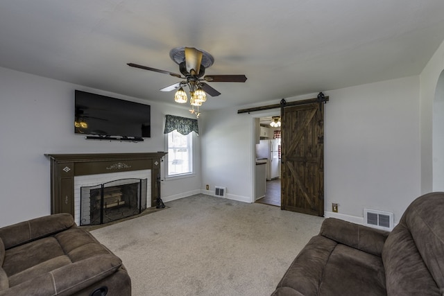 10415 W Ames Ave, Beach Park, IL 60087 - carpeted living room featuring a barn door, ceiling fan, and a fireplace with flush hearth