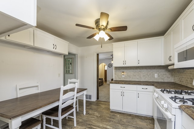 10415 W Ames Ave, Beach Park, IL 60087 - kitchen featuring ceiling fan, arched walkways, white appliances, dark wood-style floors, and decorative backsplash