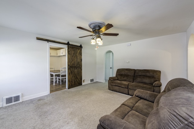 10415 W Ames Ave, Beach Park, IL 60087 - living area featuring arched walkways, a barn door, carpet flooring, and a ceiling fan