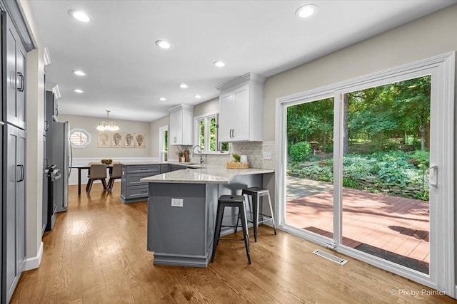 515 Timbers Trl, Saint Charles, IL 60174 - kitchen featuring a peninsula, backsplash, wood finished floors, a breakfast bar, and recessed lighting