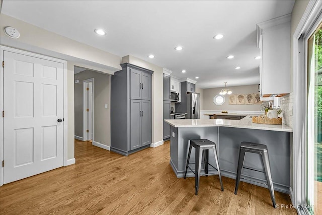 515 Timbers Trl, Saint Charles, IL 60174 - kitchen featuring stainless steel appliances, gray cabinetry, a peninsula, light wood-style floors, and recessed lighting