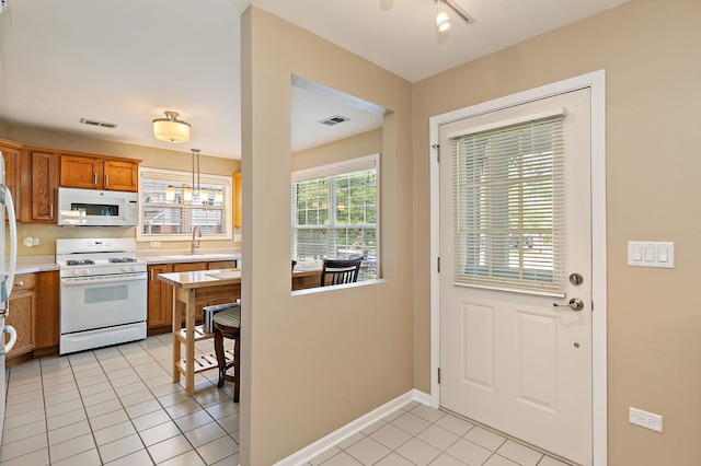 322 Winfield Ct, Schaumburg, IL 60194 - kitchen with white appliances, light tile patterned floors, light countertops, brown cabinets, and decorative light fixtures