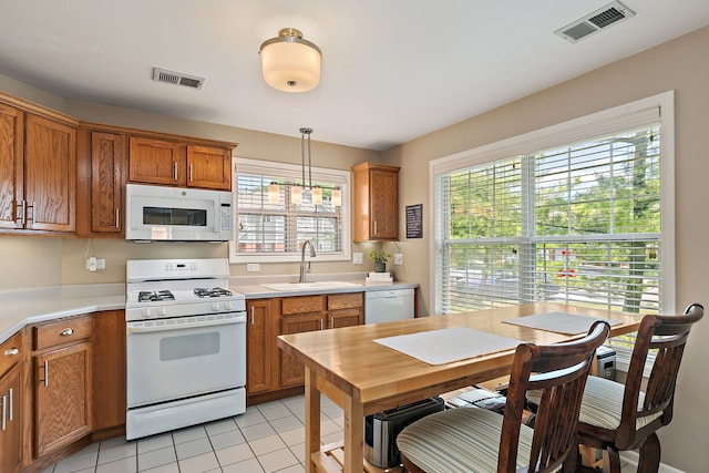 322 Winfield Ct, Schaumburg, IL 60194 - kitchen with white appliances, light countertops, brown cabinetry, light tile patterned floors, and pendant lighting