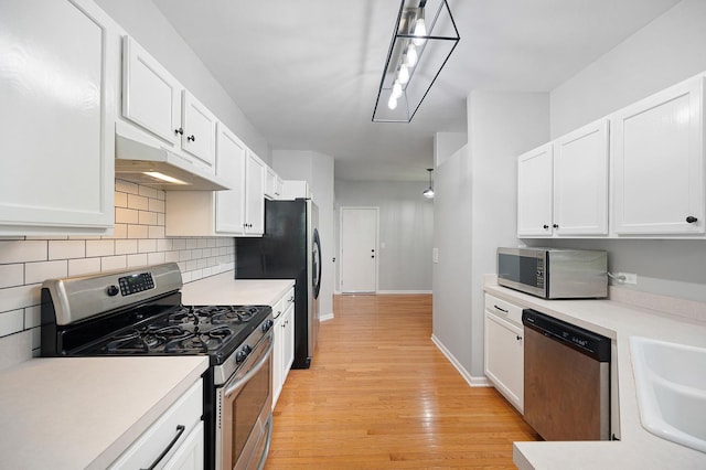 7358 Grandview Ct Unit 7358, Carpentersville, IL 60110 - kitchen featuring appliances with stainless steel finishes, under cabinet range hood, tasteful backsplash, white cabinetry, and light countertops