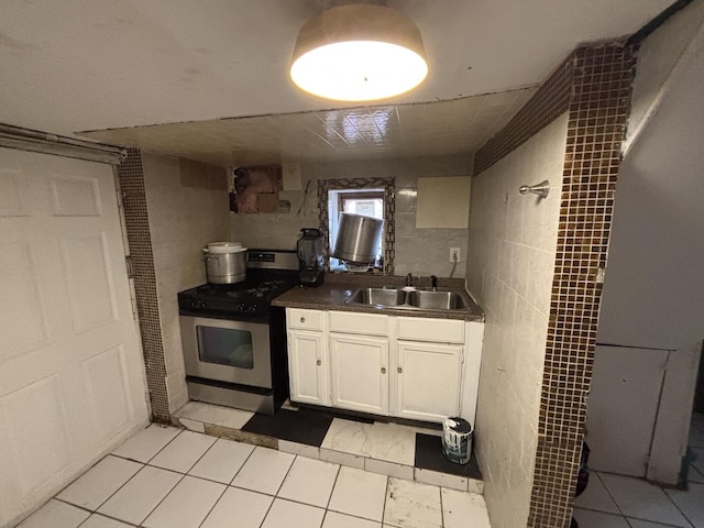 5409 S Richmond St, Chicago, IL 60632 - kitchen featuring stainless steel range with gas cooktop, white cabinetry, dark countertops, light tile patterned floors, and tile walls