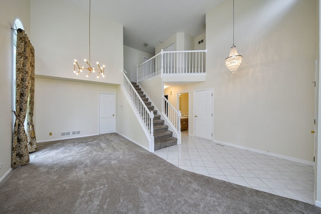 339 Windsor Dr, Bartlett, IL 60103 - unfurnished living room featuring a chandelier, carpet flooring, a high ceiling, stairs, and tile patterned floors