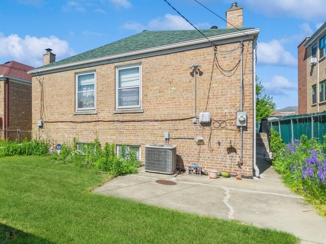 5547 N California Ave, Chicago, IL 60625 - rear view of house featuring a chimney, brick siding, a patio area, and roof with shingles