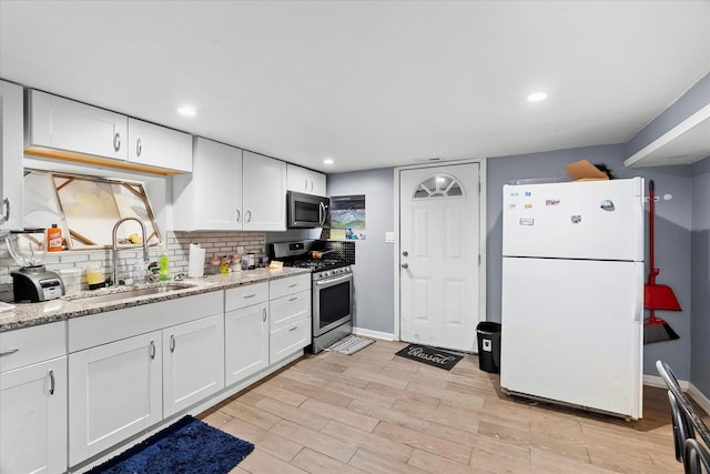 11030 S Ave L, Chicago, IL 60617 - kitchen with stainless steel appliances, white cabinets, backsplash, light wood-style flooring, and light stone counters